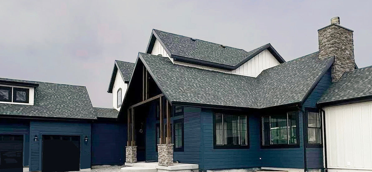 a blue house with two garages and a fire hydrant in front of it