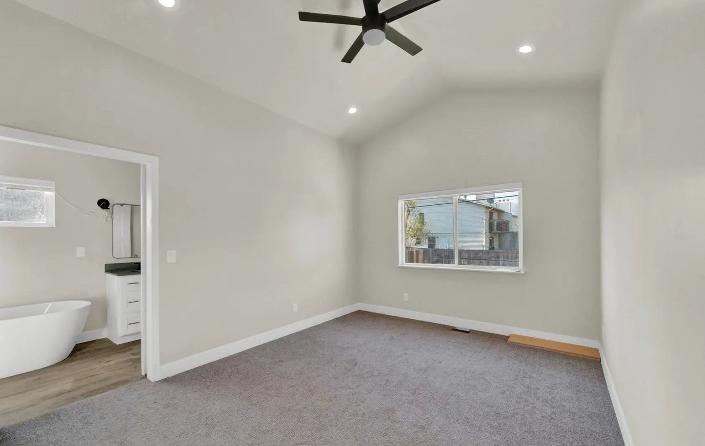 a room with a ceiling fan and a bathtub