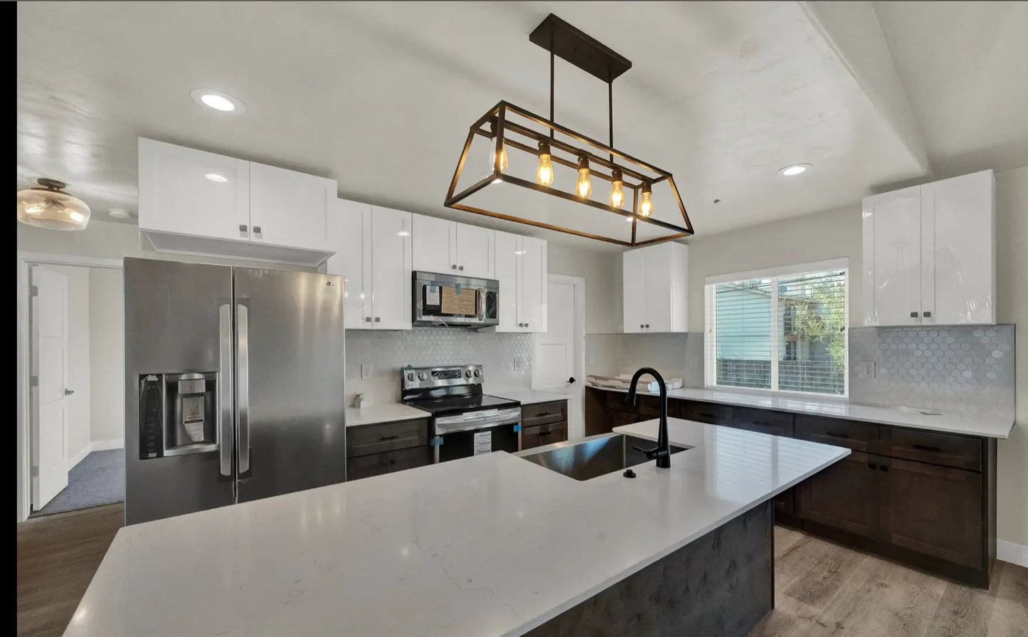 a kitchen with an island, refrigerator, stove and sink