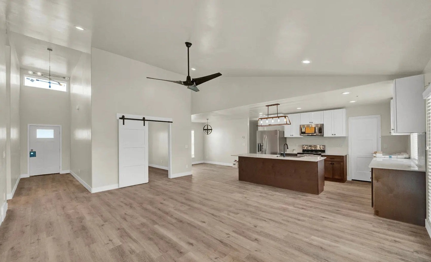 an empty living room with a ceiling fan