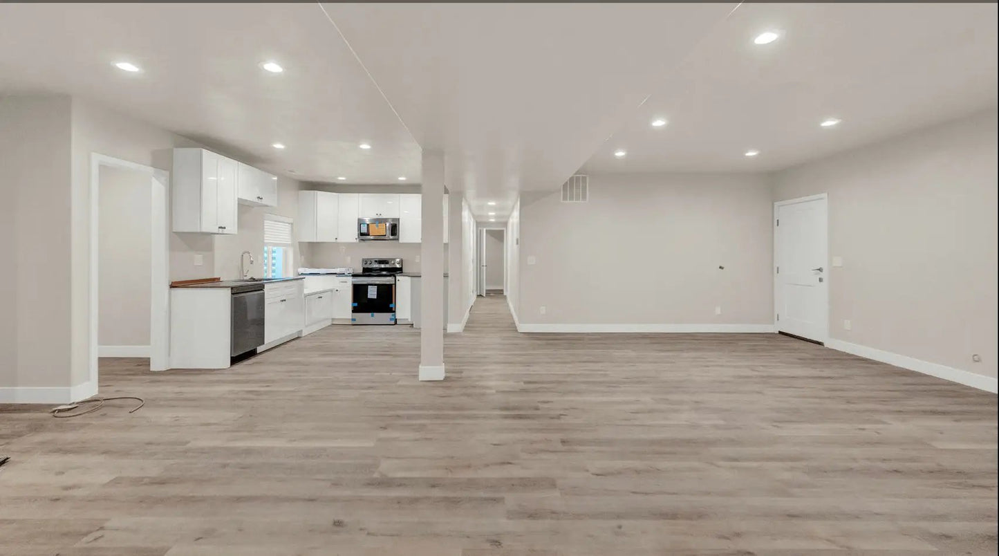 an empty living room with white walls and wood floors