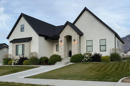 Two-story house with white exterior and black roof in a suburban setting.