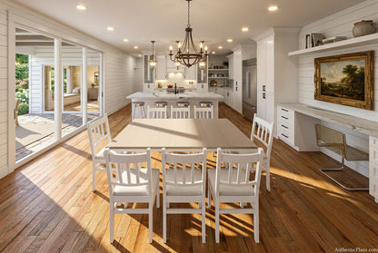 A modern dining room setup featuring a rectangular light wood dining table surrounded by six white wooden chairs, set in a bright, contemporary open-plan kitchen and dining space with light wood floors.