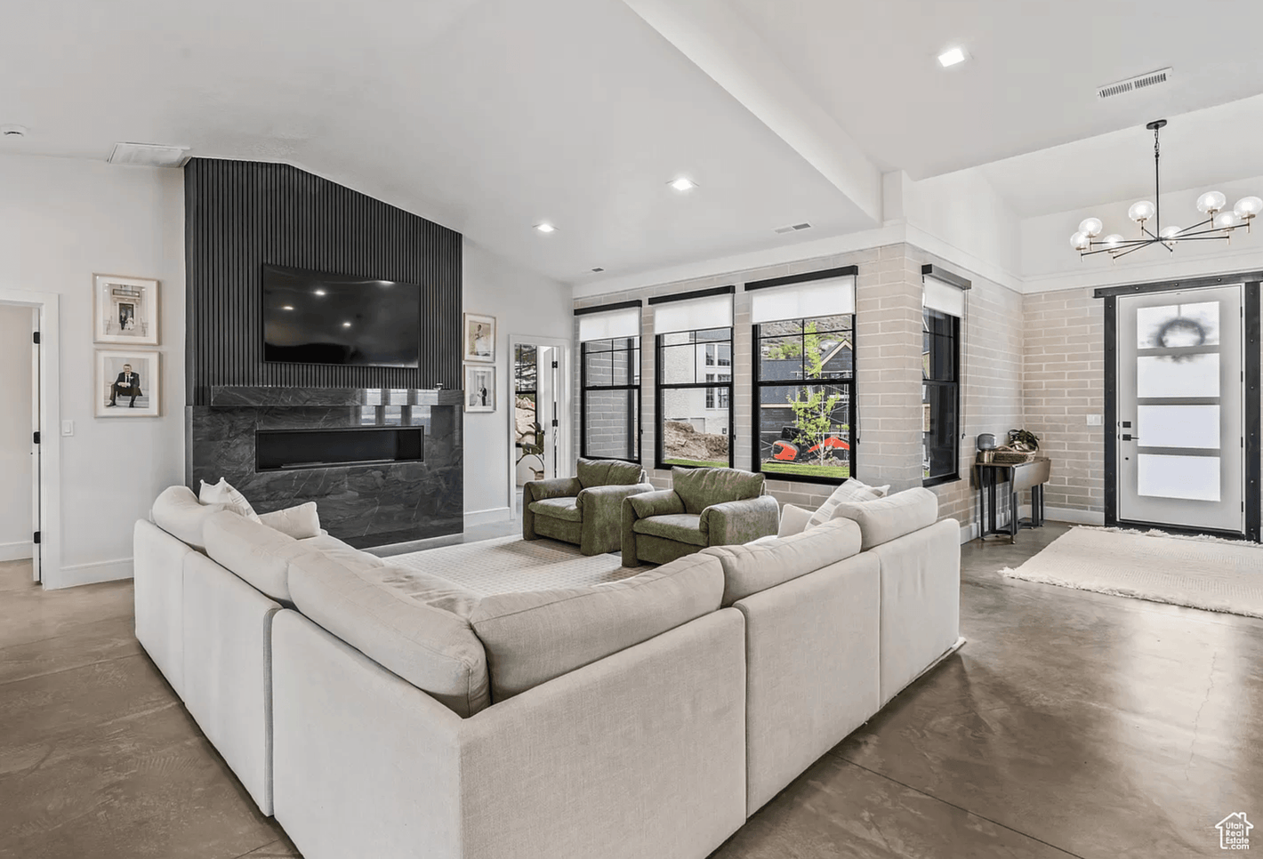 Modern No.10 house plan living room with large sectional, black tile fireplace, and floor-to-ceiling windows by Authentic Homes builder in Utah