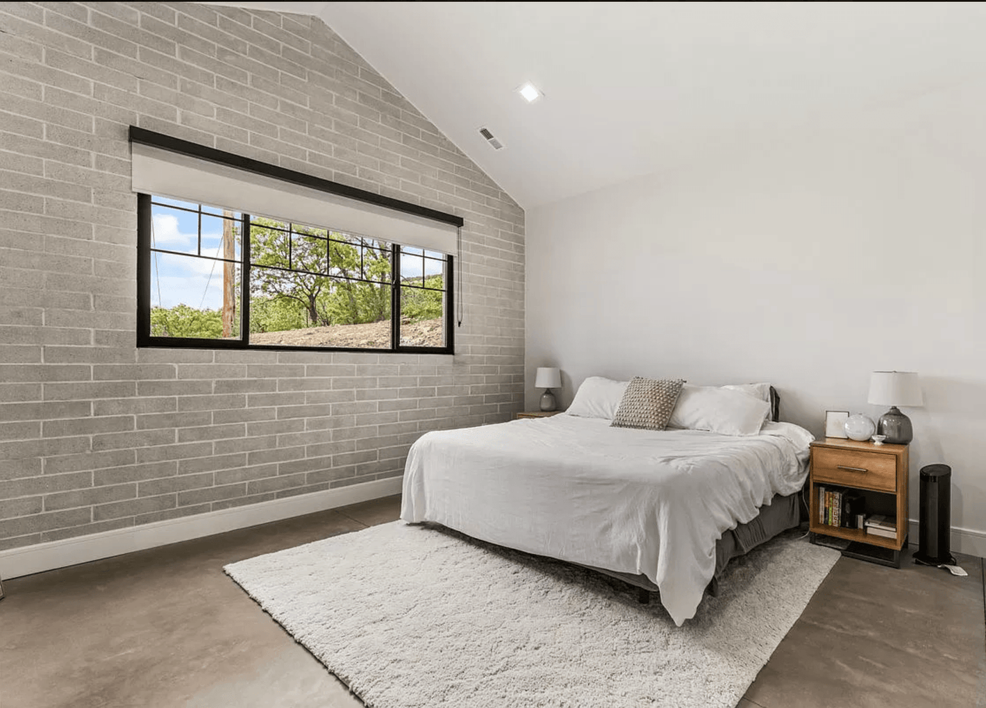Modern No.10 house plan bedroom with vaulted ceiling, concrete floor, and exposed Omniblock wall by Authentic Homes builder in Utah. Bult in Provo, Utah by Authentic Homes.