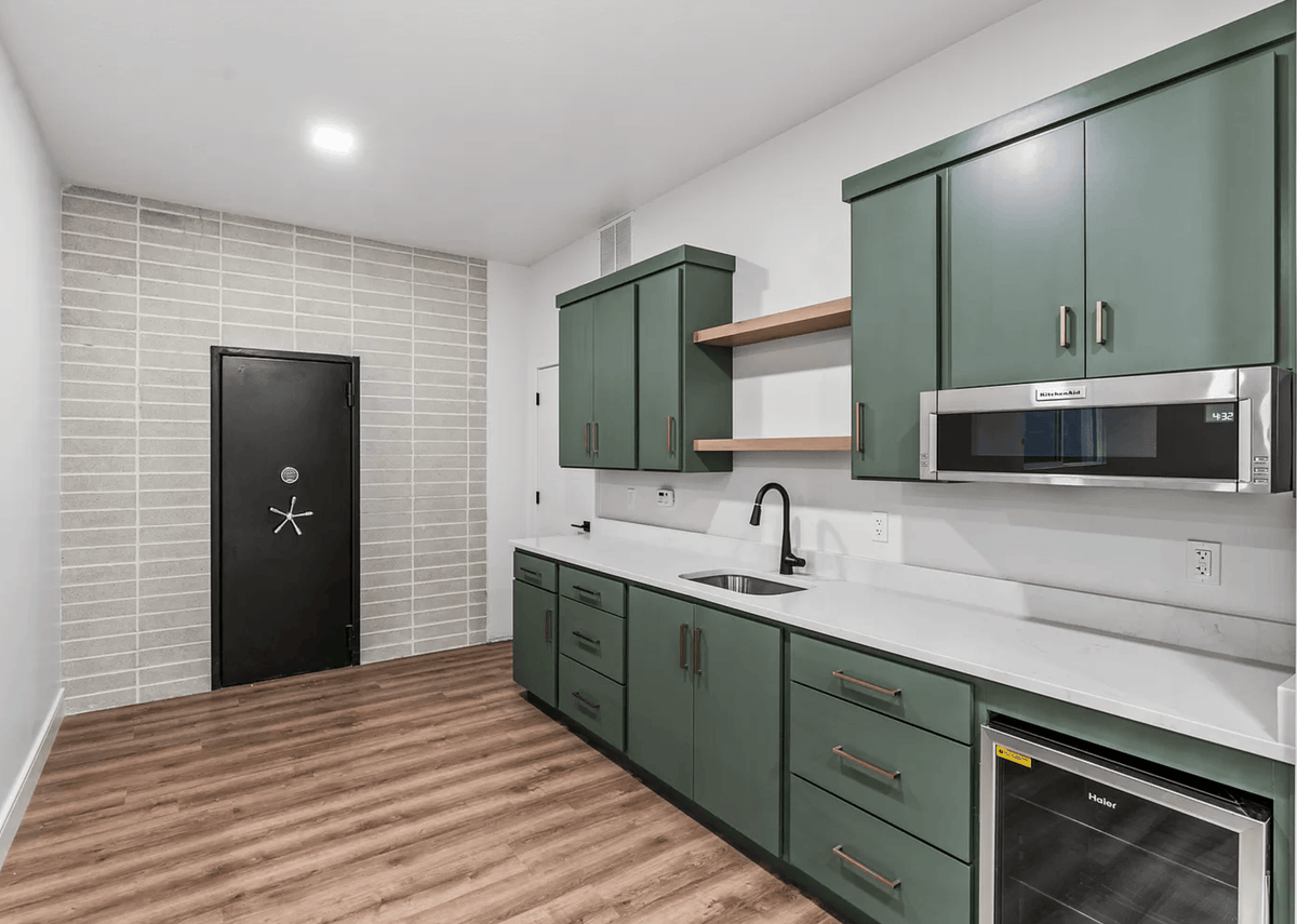 Modern No.10 house plan kitchen with green shaker cabinets, quartz countertops, and built-in microwave by Authentic Homes builder in Utah.