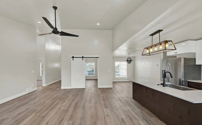 an empty kitchen and living room with a ceiling fan