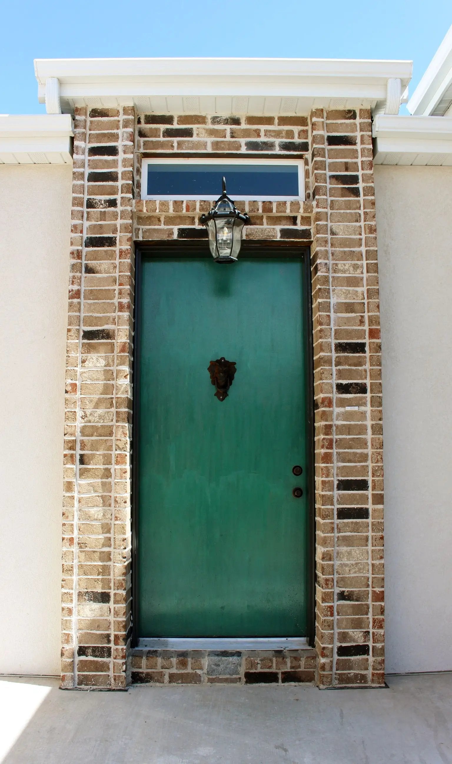 green door with brick entry